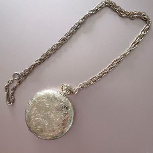 Gold locket with chain etched swirl design